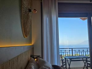 a living room with a couch and a window with a view at Yialasi Hotel in Ancient Epidauros