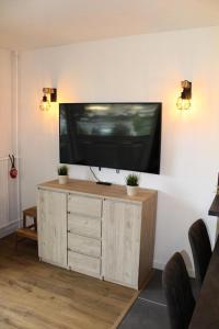 a flat screen tv on a wall in a living room at Résidence Le Bois D'aurouze - Studio pour 4 Personnes 701 in Le Dévoluy