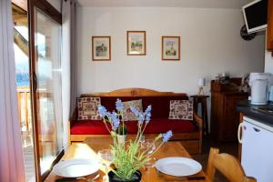 una habitación con una cama y una mesa con flores. en Les Chalets De Superd Ancolie - 2 Pièces pour 6 Personnes 741 en Le Dévoluy