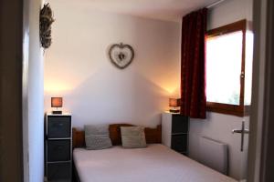 een slaapkamer met een bed en een hart aan de muur bij Les Chalets De Superd Ancolie - 2 Pièces pour 6 Personnes 741 in Le Dévoluy