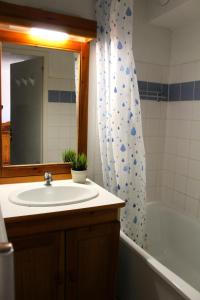 een badkamer met een wastafel, een spiegel en een bad bij Les Chalets De Superd Ancolie - 2 Pièces pour 6 Personnes 741 in Le Dévoluy