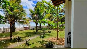 vistas a un patio con palmeras y al océano en Pearl Oceanic Resort - Trincomalee, en Trincomalee