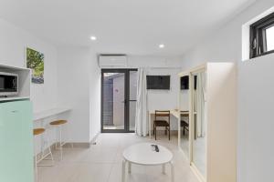 una cucina bianca con tavolo bianco in una stanza di Bright Studio Apartment in Surry Hills' Heart a Sydney