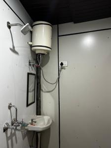 een badkamer met een wastafel en een lampje aan de muur bij Brahma Kamal in Phata