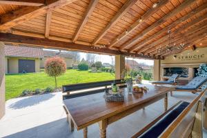 a patio with a wooden pergola and a table at Hedonistic Vineyard Estate With Hot Tub - Happy Rentals in Ludbreg