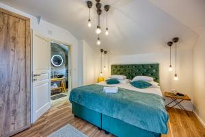 a bedroom with a large bed with a blue bedspread at Hedonistic Vineyard Estate With Hot Tub - Happy Rentals in Ludbreg +26 photos