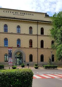 un edificio con un cartel en la parte delantera en Appartamento centrale, en Tortona