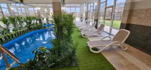 a row of chairs and a pool in a building at Luby Panzió in Nagyar