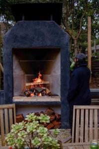un hombre parado frente a un horno de fuego en Harrys House Warburton - Peaceful Riverside cottage in the perfect location, en Warburton
