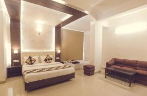 a bedroom with a king sized bed and a couch at Sangam Resort, pilani in Chirāwa