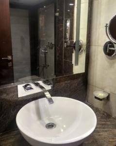 - Baño con lavabo blanco y ducha en Sangam Resort, pilani, en Chirāwa