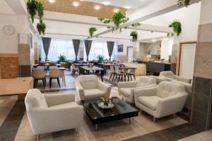 a lobby with chairs and tables and a restaurant at Luby Panzió 