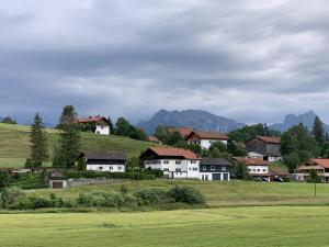 a group of houses on a hill with mountains in the background at Ferienhaus Frank Grieser in Hopferau