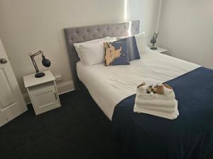 a bedroom with a bed with towels and a lamp at Clubhouse Hotel Yass in Yass