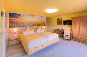 DamnatzにあるSonnenhof Damnatz -Hotel garni-のベッドルーム1室(ベッド1台付)が備わります。壁には絵画が飾られています。