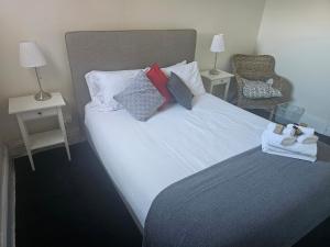 a bedroom with a large white bed with pillows at Clubhouse Hotel Yass in Yass