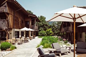 a patio with tables and chairs and an umbrella at L'Alpaga, a Beaumier hotel in Megève
