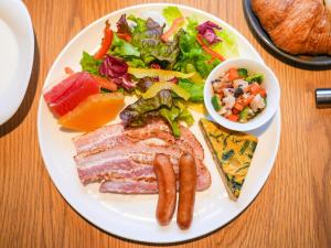 a white plate of food with sausage and a salad at THE GENERAL KYOTO Bukkouji Shinmachi in Kyoto