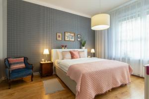 een slaapkamer met een bed en een blauwe muur bij Smile Apartments Center Kraków Old Town in Krakau