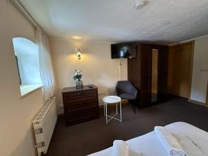 a hotel room with a bed and a desk and a chair at Amara.Festsaal.Gasthaus.Pension in Mohorn