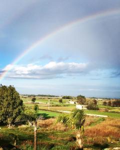 a rainbow in the sky over a field with trees at B&B Francesca in Scorrano