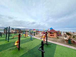 a park with a playground with slides at Raduga West 'Emerald' Cottage in Koshkolʼ