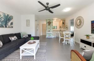 a living room with a couch and a ceiling fan at Unit 4 @ Tropical Reef Apartments in Port Douglas