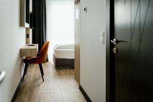 sypialnia z łóżkiem, biurkiem i drzwiami w obiekcie Lamede w mieście Wiener Neustadt