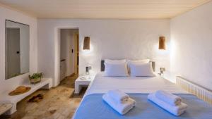 a bedroom with a large white bed with towels on it at BLUE VILLA in Kampos Paros +34 photos