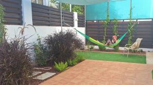 una chica sentada en una hamaca en un jardín en The T Villa, en Protaras 6 fotos más