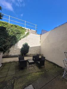 a patio with chairs and a table next to a wall at Recently Renovated Dublin City House in Dublin