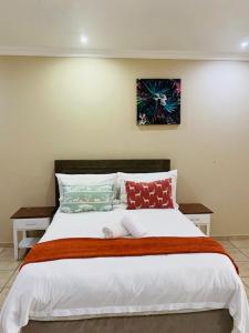 a bedroom with a large white bed with pillows at St. Lucia Safari Lodge in St Lucia