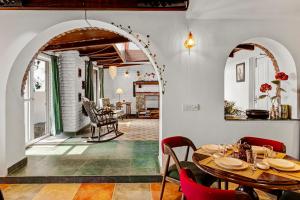 a dining room with an archway and a table and chairs at SaffronStays Wilbury Homes - The Cheese Villa in Mussoorie