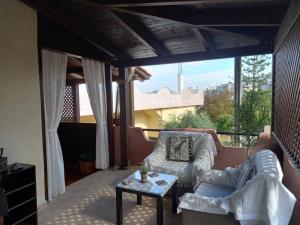een patio met 2 banken en een tafel op een balkon bij Gorgona Apt in Heraklion