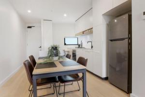 a kitchen and dining room with a table and chairs at Modern Apartment Overlooking Leafy Ivanhoe in Melbourne