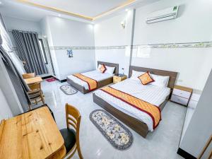 ein Hotelzimmer mit 2 Betten, einem Tisch und Stühlen in der Unterkunft homestay Phúc Lũy in Cu Lao Thu
