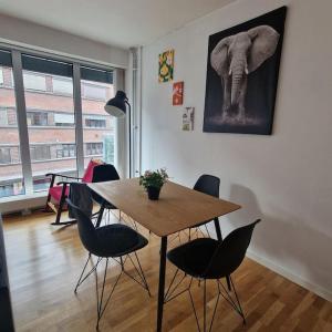 een eetkamer met een tafel en stoelen en een schilderij van een olifant bij Serene 1 bedroom apartment Oslo in Oslo