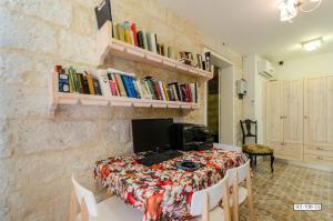 a room with a table with a computer and books at Alexandra House in Nazareth