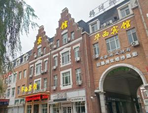 a red brick building with chinese writing on it at Harbin Huaxi Hotel - Ice World Branch in Harbin