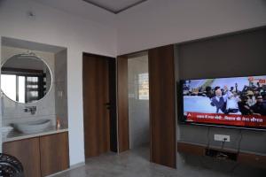 uma casa de banho com uma televisão de ecrã plano na casa de banho em Gulmohar Homes em Udaipur