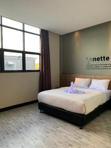 Un dormitorio con una cama con una bata morada. en BLESS HOTELS en Sintang