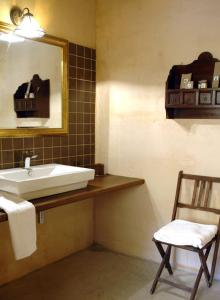 a bathroom with a sink and a mirror and a chair at La Premsa Hotel Rural in Cardona +9 photos