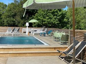 a swimming pool with chairs and tables and an umbrella at Brösarps Gästgifveri & SPA in Brösarp