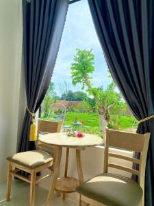 einen Tisch und Stühle in einem Zimmer mit Fenster in der Unterkunft Hotel Cù Lao 3 (TiTi) in Tây Ninh