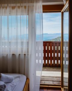 a bedroom with a bed and a large window at Hotel Lukov Dom in Mislinja