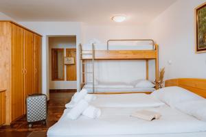 two beds in a room with two bunk beds at Hotel Lukov Dom in Mislinja