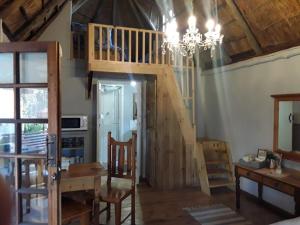 a room with a staircase and a table and a chandelier at Oudam Overnight Accomodation in Bloemfontein