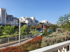 a view of a park with a playground and buildings at Lavi La in Modi'in-Maccabim-Re'ut