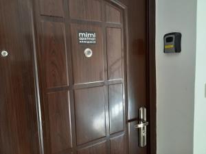 a wooden door with a sign on it at Mimi Apartman in Szeged