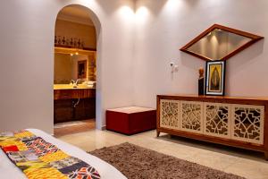 y baño con cama, espejo y lavabo. en Elegant Garden & 2Living Areas, 2 Bed Rooms for 6 Guests, en Umm al ‘Amad